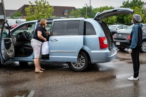 woman placing bags of food in mini van