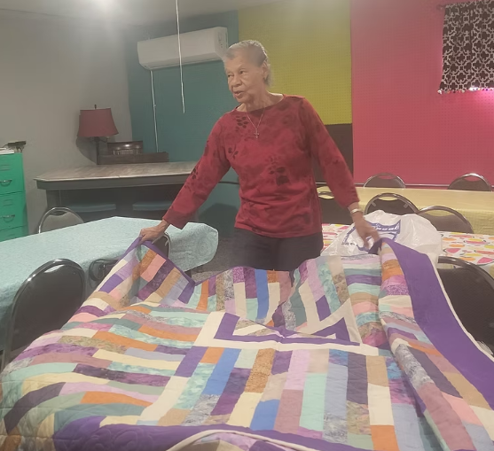 Person holding up quilt